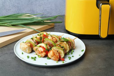 Gri masada tavuklu, sebzeli ve fritözlü lezzetli şişler.