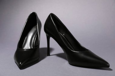 Pair of stylish high heeled shoes on gray background, closeup