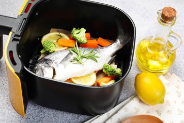 Çiğ balık, limon ve sebzeler açık gri masada, yakın plan.