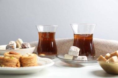 Geleneksel Türk çayı, esmer şeker ve tatlılar beyaz masada, yakın plan