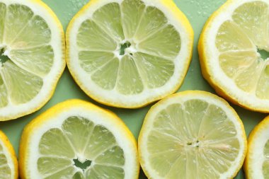 Açık yeşil zemin üzerinde limon ve su damlaları, üst görünüm