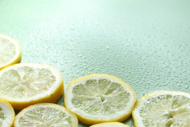 Açık yeşil arka planda limon ve su damlaları, yakın plan. Metin için boşluk