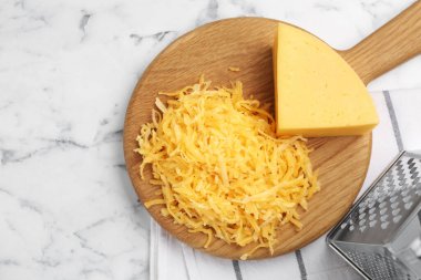 Beyaz mermer masada rendelenmiş ve rendelenmiş peynir.