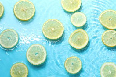 Açık mavi zemin üzerinde limon dilimleri, düz uzanmış