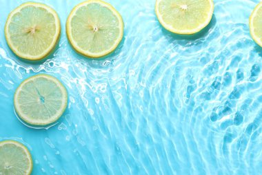 Açık mavi arka planda limon dilimleri, düz. Metin için boşluk