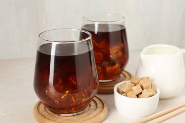 Lezzetli buzlu kahve, süt ve şeker beyaz masada, yakın plan.