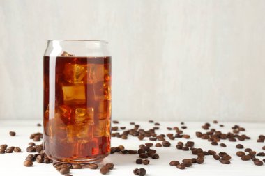 Beyaz ahşap masada lezzetli buzlu kahve ve fasulye. Metin için boşluk