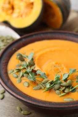 Çekirdekli balkabağı çorbası ve masada mikro yeşiller, yakın plan.