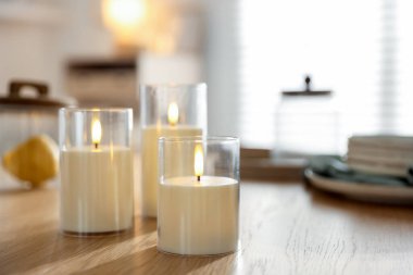 Kapalı alandaki ahşap masada güzel LED mumlar, yakın plan. Metin için boşluk