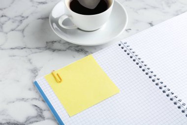 Boş not, not defteri ve kahve fincanı beyaz mermer masada, yakın plan. Metin için boşluk