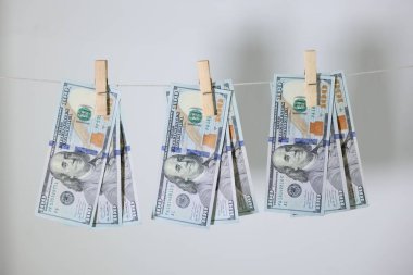 Para aklama. Banknotlar açık gri arkaplanda çamaşır ipinde asılı