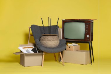 Garaj satışı. Sarı arkaplanda farklı kullanılmış eşyalar