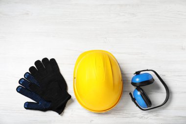 Beyaz ahşap masada farklı güvenlik ekipmanları var. Metin için boşluk