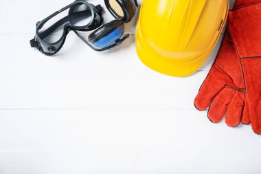 Beyaz ahşap masada farklı güvenlik ekipmanları var. Metin için boşluk