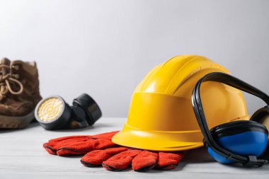 Beyaz ahşap masada farklı güvenlik ekipmanları, seçici odaklanma. Metin için boşluk