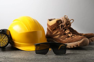 Gri masada farklı güvenlik ekipmanları, yakın plan.