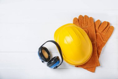 Beyaz ahşap masada farklı güvenlik ekipmanları var. Metin için boşluk