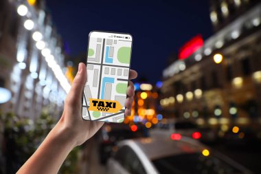 Cep telefonundaki uygulamayı kullanarak şehir caddesinde bir taksi çağıran adam.
