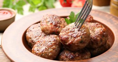 Lezzetli köfteyi çatalla alıp sosa batırıyorum.