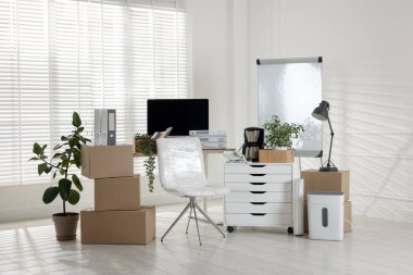 Taşınma günü. Mukavva kutular, bilgisayar ve mobilyalar ofiste.