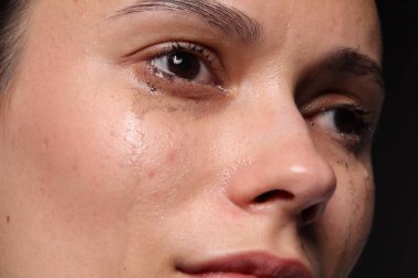 Üzgün kadın siyah arka planda ağlıyor, yakın plan