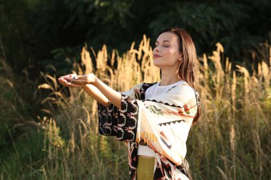 Kadın dışarıda atmosferini iyileştirmek ya da iyileştirmek için kristallerle meditasyon yapıyor.