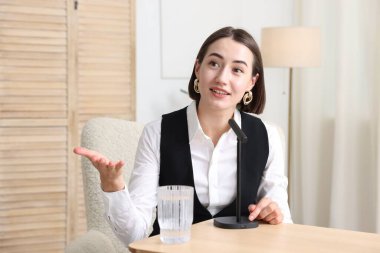 Podcast sunucusu stüdyoda mikrofona konuşuyor