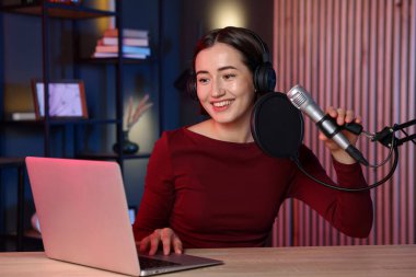 Podcast sunucusu stüdyoda talk show kaydediyor.