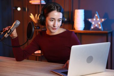 Podcast sunucusu stüdyoda talk show kaydediyor.