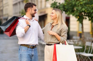 Farklı alışveriş çantaları olan mutlu bir çift.