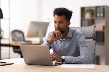 ofiste masada dizüstü bilgisayarda çalışan adam