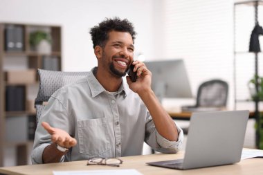 Ofiste akıllı telefondan konuşan bir adam.