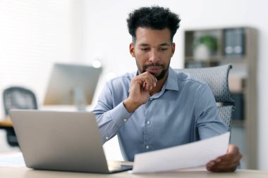 Ofiste çalışan belgesi olan bir adam.