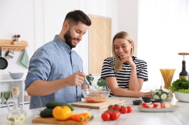 Mutfakta birlikte yemek pişiren mutlu çift.