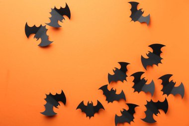 Cadılar Bayramı dekoru. Siyah kağıt yarasalar turuncu arka planda, düz yerde. Metin için boşluk