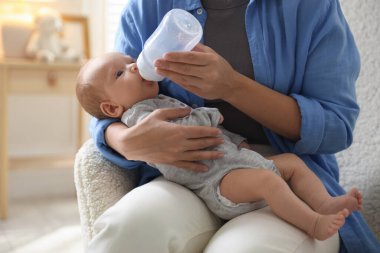 Anne bebeğini biberonla besliyor.