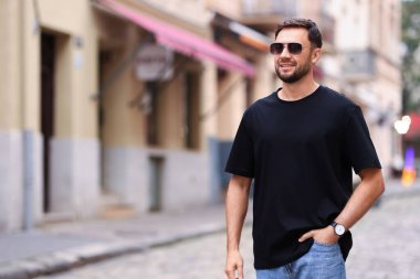 Açık havada siyah tişört giyen bir adam. Tasarım için model