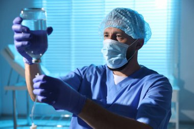 Doktor, klinikte gece vardiyası sırasında serum takıyor.