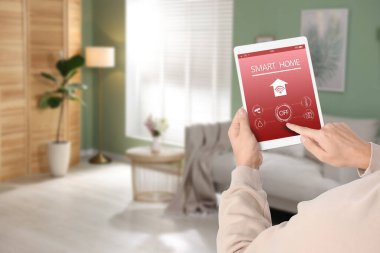 Tablet bilgisayarda ev özelliklerini kontrol etmek için akıllı ev uygulaması kullanan adam, kapat