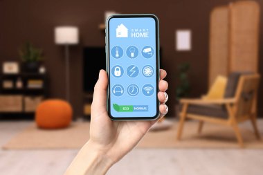 Odada akıllı ev uygulaması kullanan bir kadın, yakın plan.