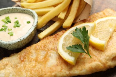 Sos, limon ve maydanozlu İngiliz Geleneksel Balık ve patates kızartması.