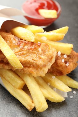 British Traditional Fish and chips with sauce on grey table, closeup