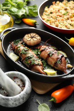 Lezzetli kalamar soslu, sarımsaklı ve siyah masada ürünler, yakın plan.