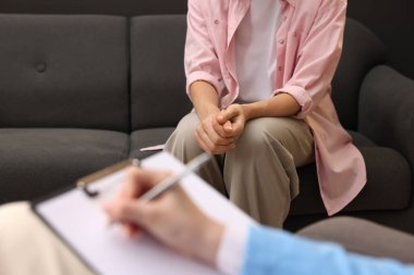 Hasta ile çalışan profesyonel psikolog ve ofiste panoya yazı yazmak, yakın plan.