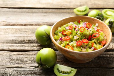 Kasede lezzetli salsa sosu ve ahşap masada yeşil domatesler, yakın plan. Metin için boşluk