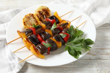 Lezzetli ızgara sebzeli şişler beyaz ahşap masada, yakın plan.