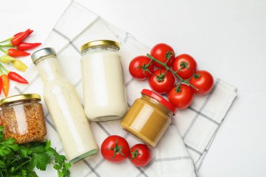 Farklı lezzetli soslar ve sebzeler ahşap masada, düz yerde.