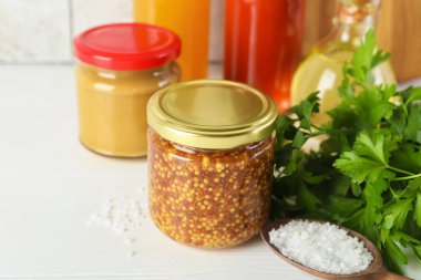 Farklı lezzetli soslar, maydanoz ve beyaz ahşap masaya tuz, yakın plan.