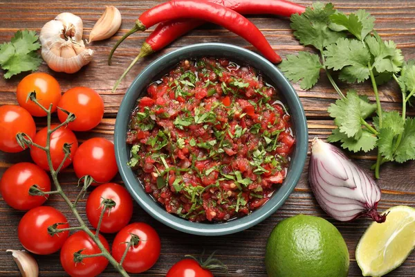 Tasty salsa sauce and ingredients on wooden table, flat lay