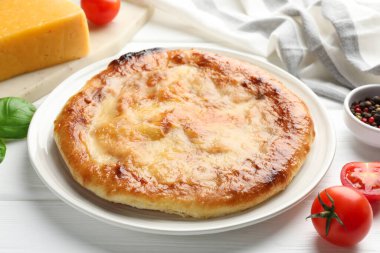 Lezzetli Megrelian Khachapuri ve beyaz ahşap masa üzerindeki ürünler.